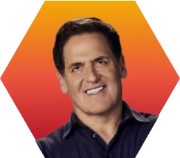 A smiling man with short dark hair wearing a dark shirt, posed in front of an orange and red gradient hexagonal background.